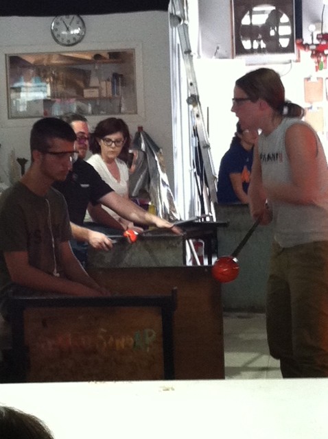 Students learning the glassblowing process from a Hot Sands employee.