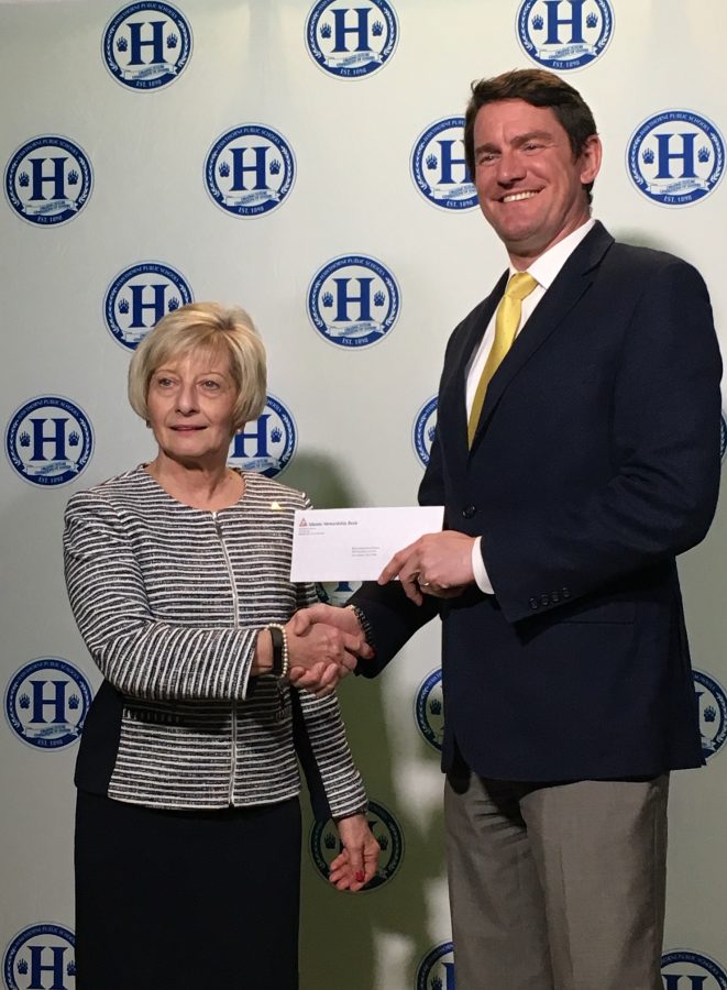 Mrs. Tilstra hands Mr. LaGrone a $250 check for the High School