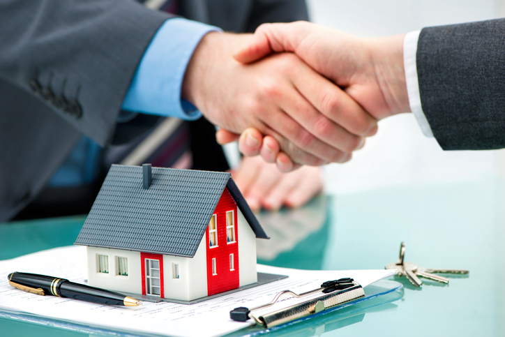 Estate+agent+shaking+hands+with+customer+after+contract+signature