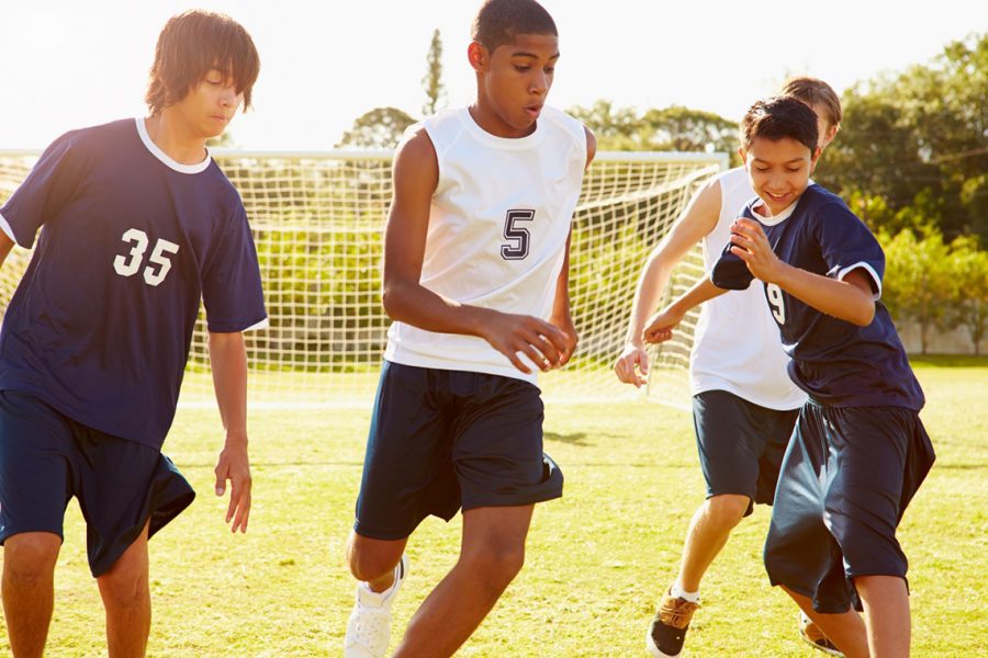 Members Of Male High School Soccer Playing Match