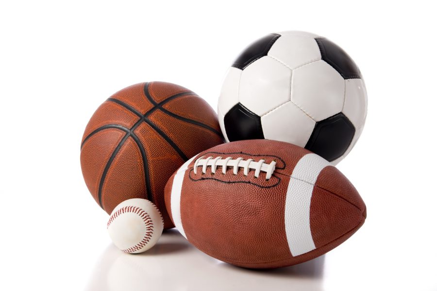 A variety of sports balls including a football, basketball, baseball and a soccer or European football